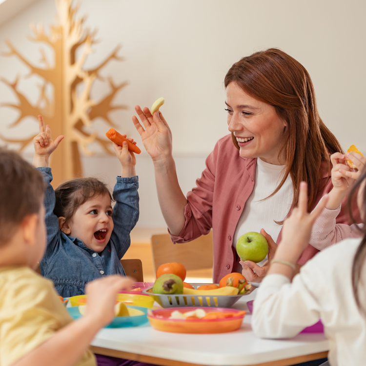 Lunchtime with nursery teacher and children