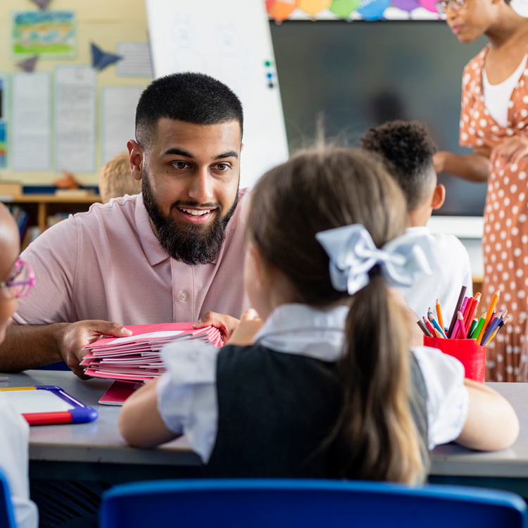 Male teacher with two students engaged